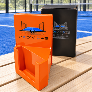 Support PAD’VIEWS orange et sa boîte sur un banc au bord d’un terrain de padel — photo retouchée.